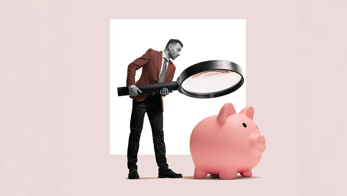 person inspecting piggy bank with magnifying glass